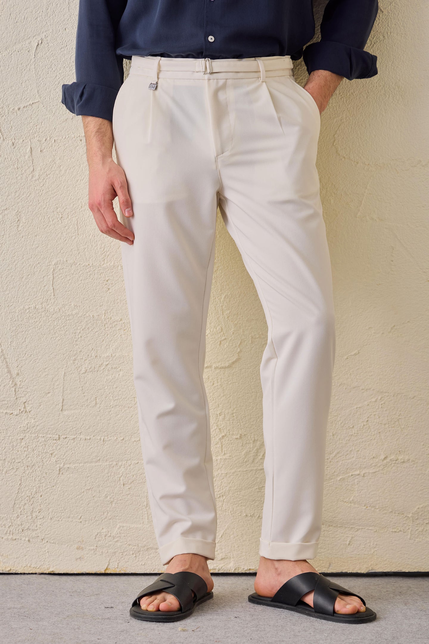 Calças Gurkha masculinas creme com pregas, cintura ajustável e corte afunilado.
