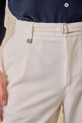 Calças Gurkha masculinas creme com pregas, cintura ajustável e corte afunilado.