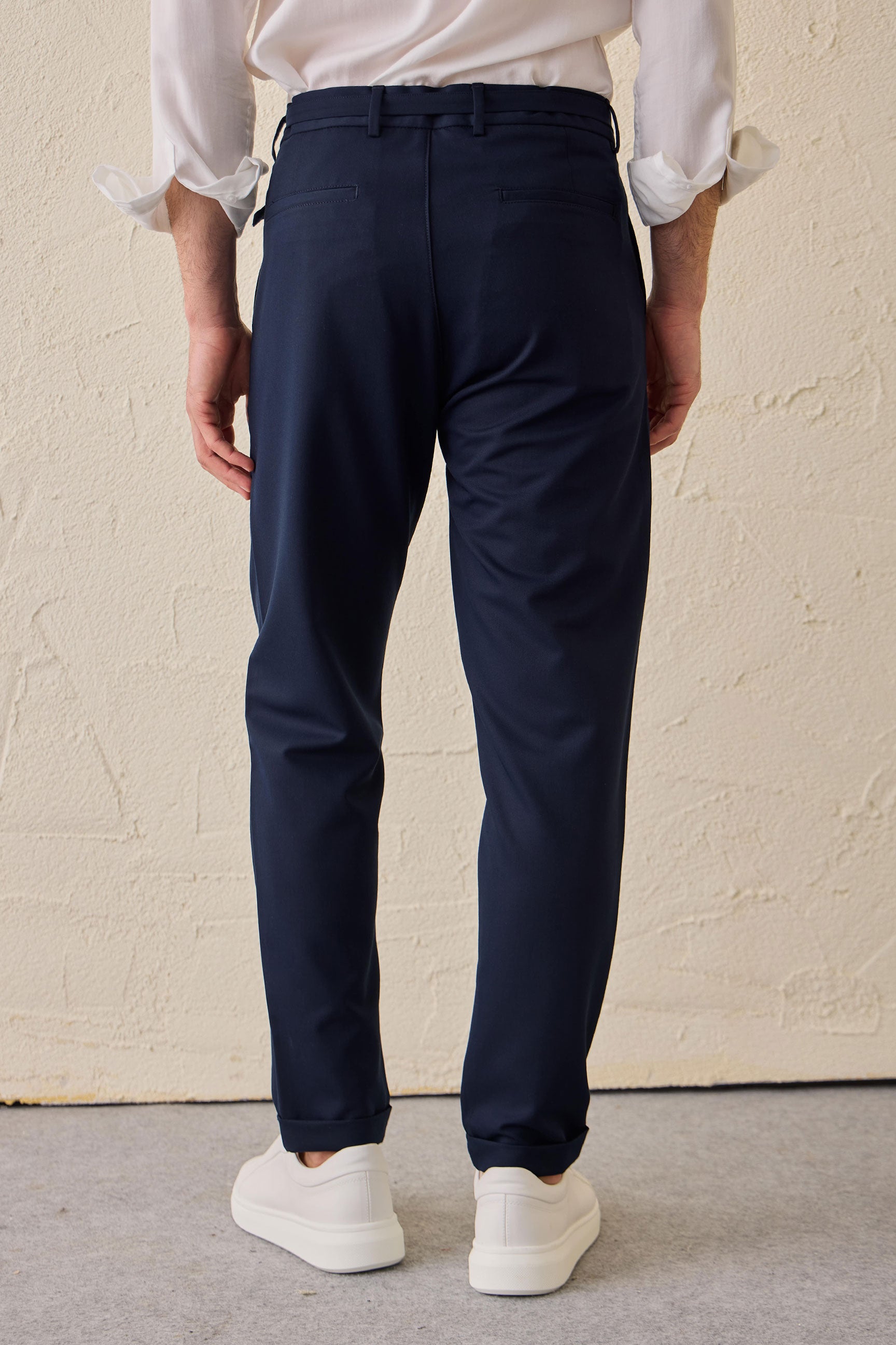 Calças Gurkha masculinas azul-marinho com pregas, cintura ajustável e corte afunilado.