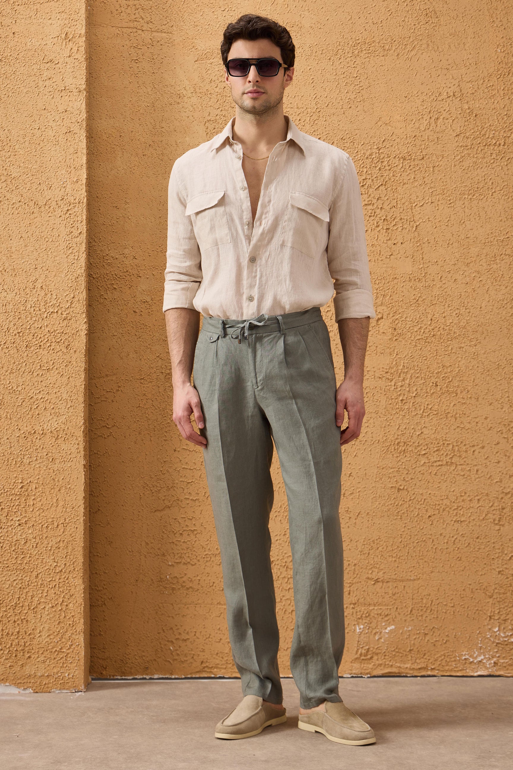 Terno masculino de linho verde sálvia, estilo safari, elegante e casual, com zíper frontal. Ideal para o verão.