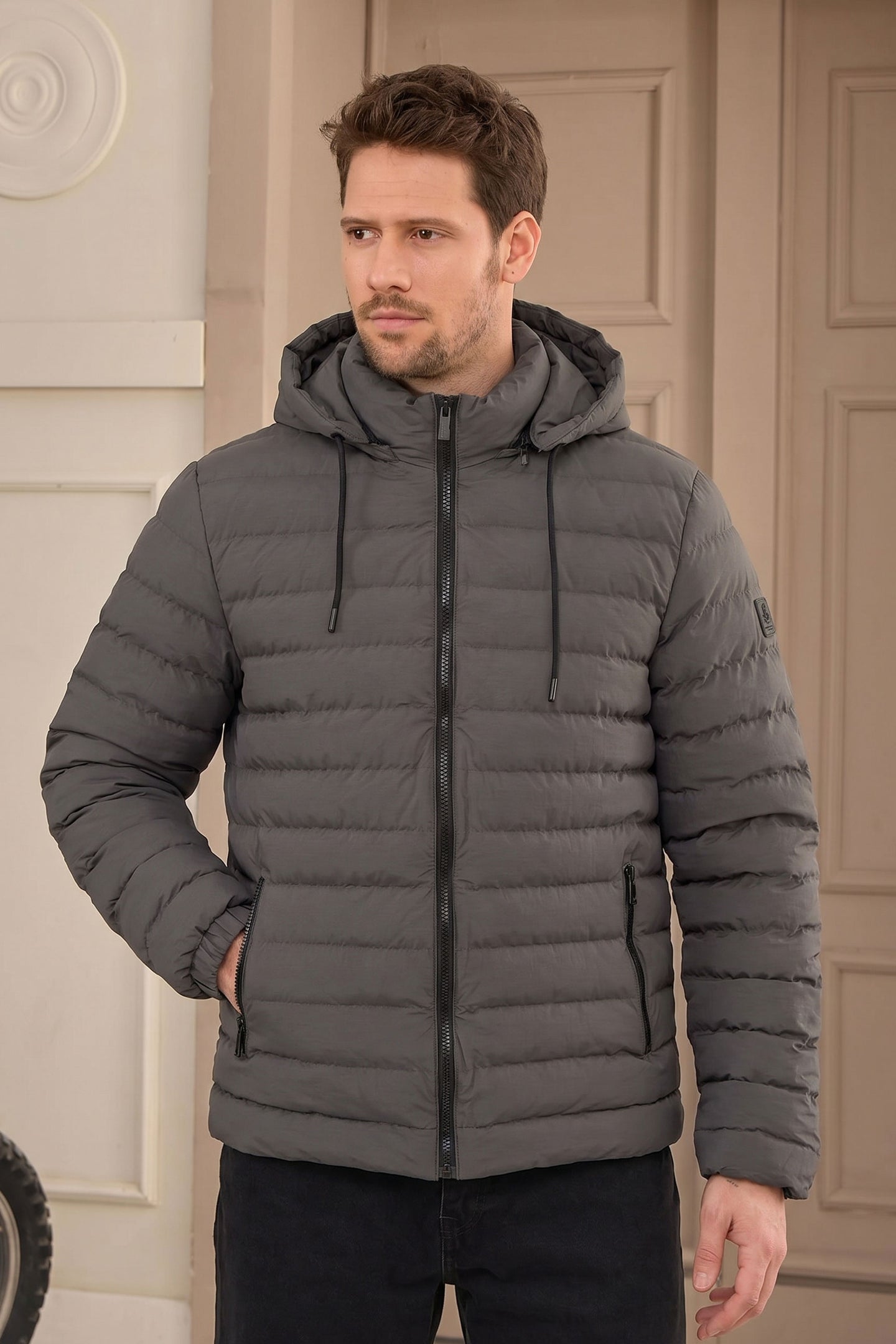 Jaqueta puffer masculina cinza com capuz, leve e acolchoada, com zíper.