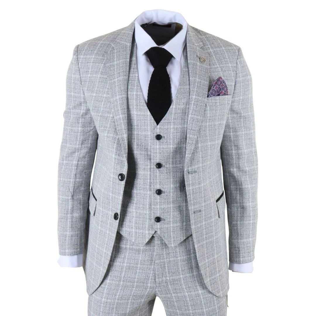 Terno xadrez cinza com gravata preta e lenço de bolso roxo sobre fundo branco.