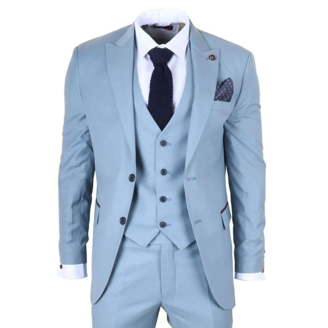 Terno azul claro com camisa branca, gravata escura e lenço de bolso sobre fundo branco.
