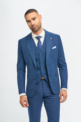 Homem vestindo terno azul com camisa branca e gravata azul sobre fundo branco