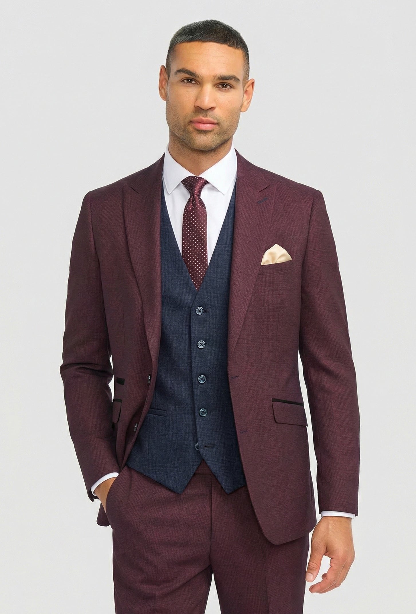 Terno masculino xadrez bordô com colete azul-marinho contrastante.