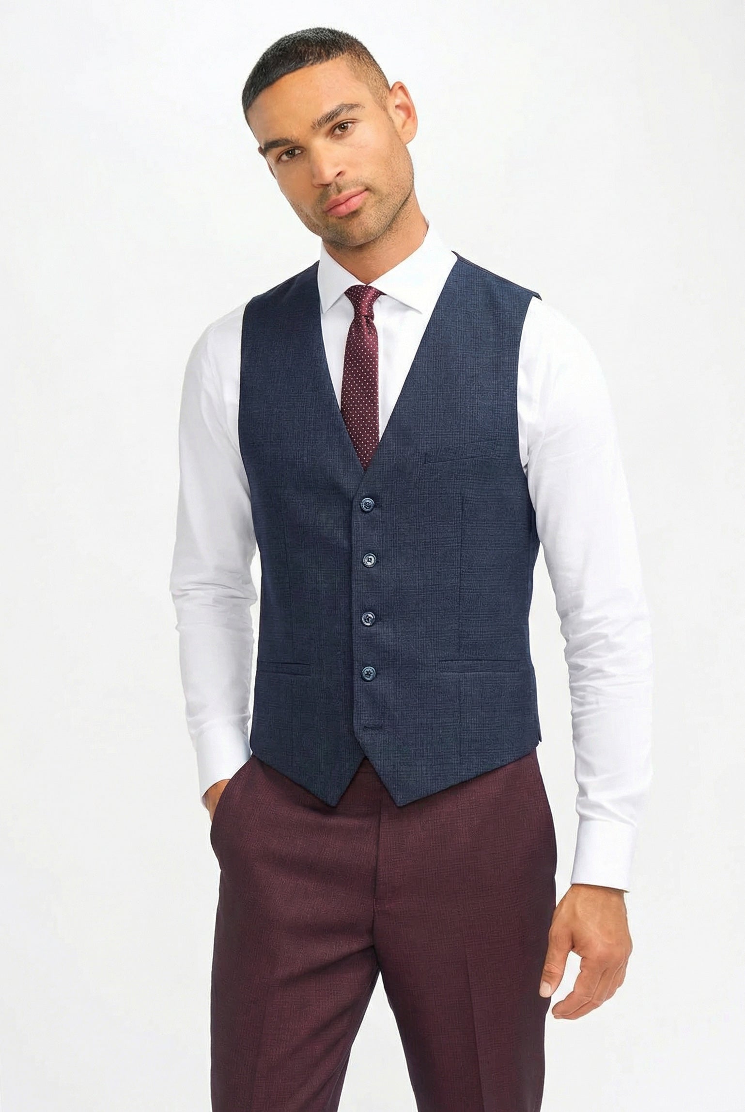 Terno masculino xadrez bordô com colete azul-marinho contrastante.