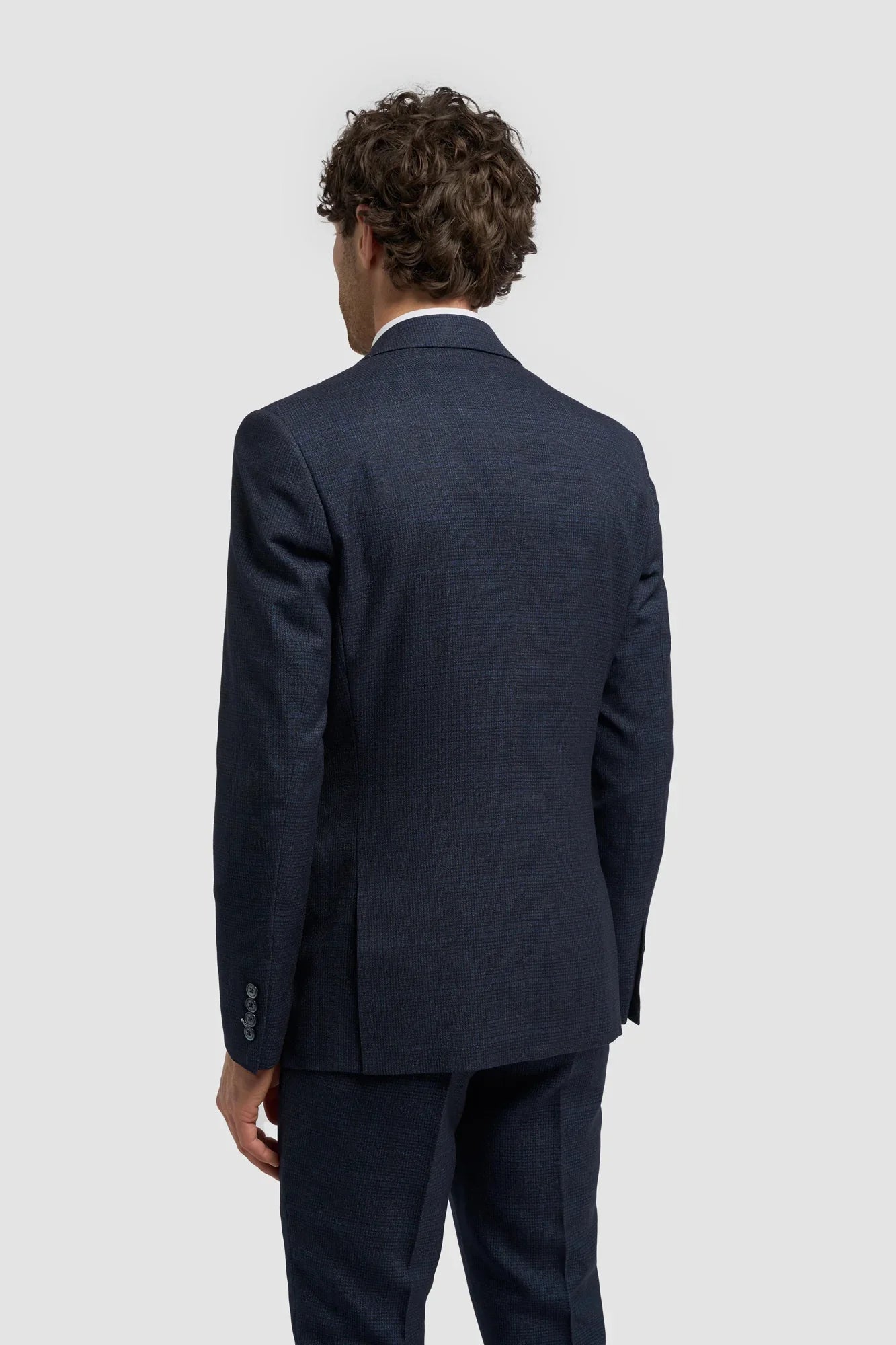 Terno masculino de três peças xadrez azul marinho com colete creme contrastante.