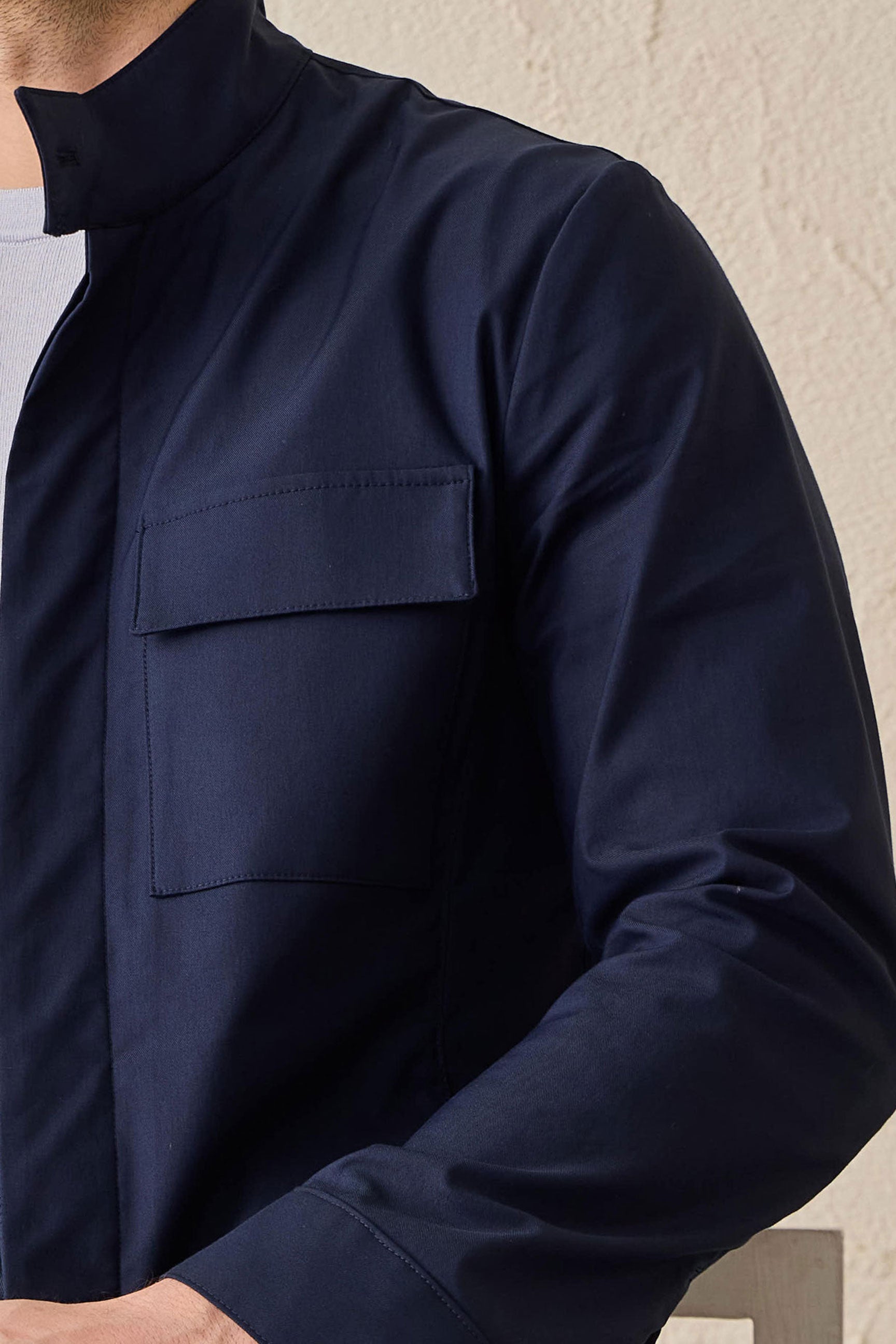 Conjunto masculino elegante e casual com jaqueta safari em mistura de algodão azul-marinho e calça branca.