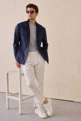 Conjunto masculino elegante e casual com jaqueta safari em mistura de algodão azul-marinho e calça branca.