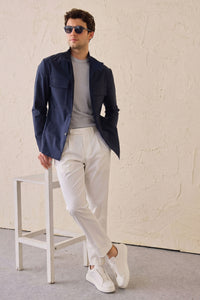 Conjunto masculino elegante e casual com jaqueta safari em mistura de algodão azul-marinho e calça branca.