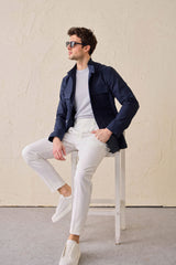 Conjunto masculino elegante e casual com jaqueta safari em mistura de algodão azul-marinho e calça branca.