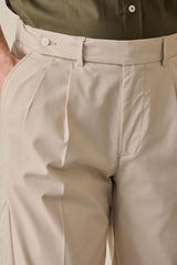 Conjunto masculino casual elegante com jaqueta safari verde-sálvia em mistura de algodão e calça bege.