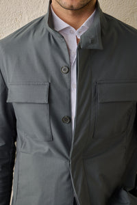 Conjunto masculino casual elegante com jaqueta safari verde-sálvia em mistura de algodão e calça bege.