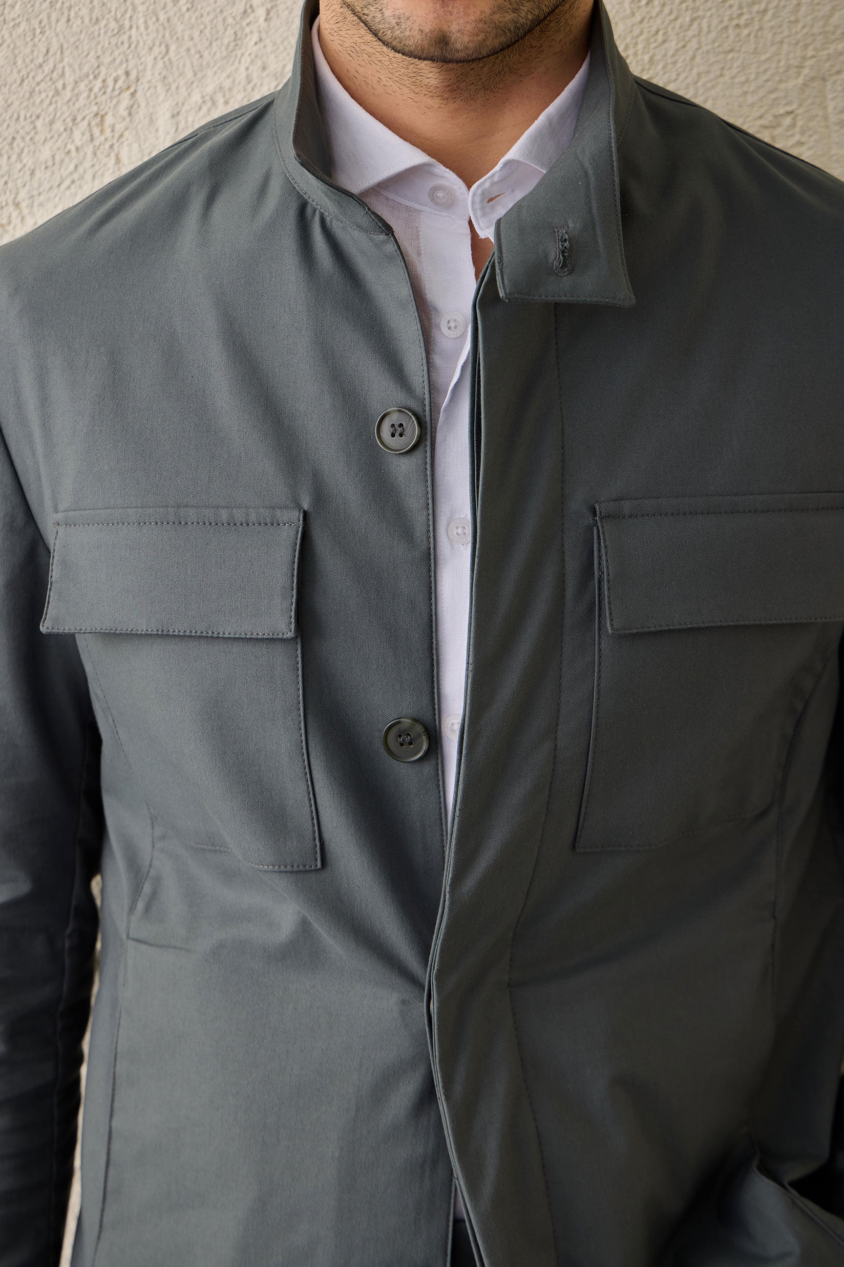 Conjunto masculino casual elegante com jaqueta safari verde-sálvia em mistura de algodão e calça bege.