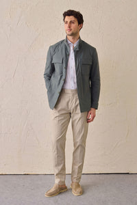 Conjunto masculino casual elegante com jaqueta safari verde-sálvia em mistura de algodão e calça bege.
