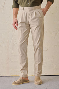 Conjunto masculino casual elegante com jaqueta safari verde-sálvia em mistura de algodão e calça bege.