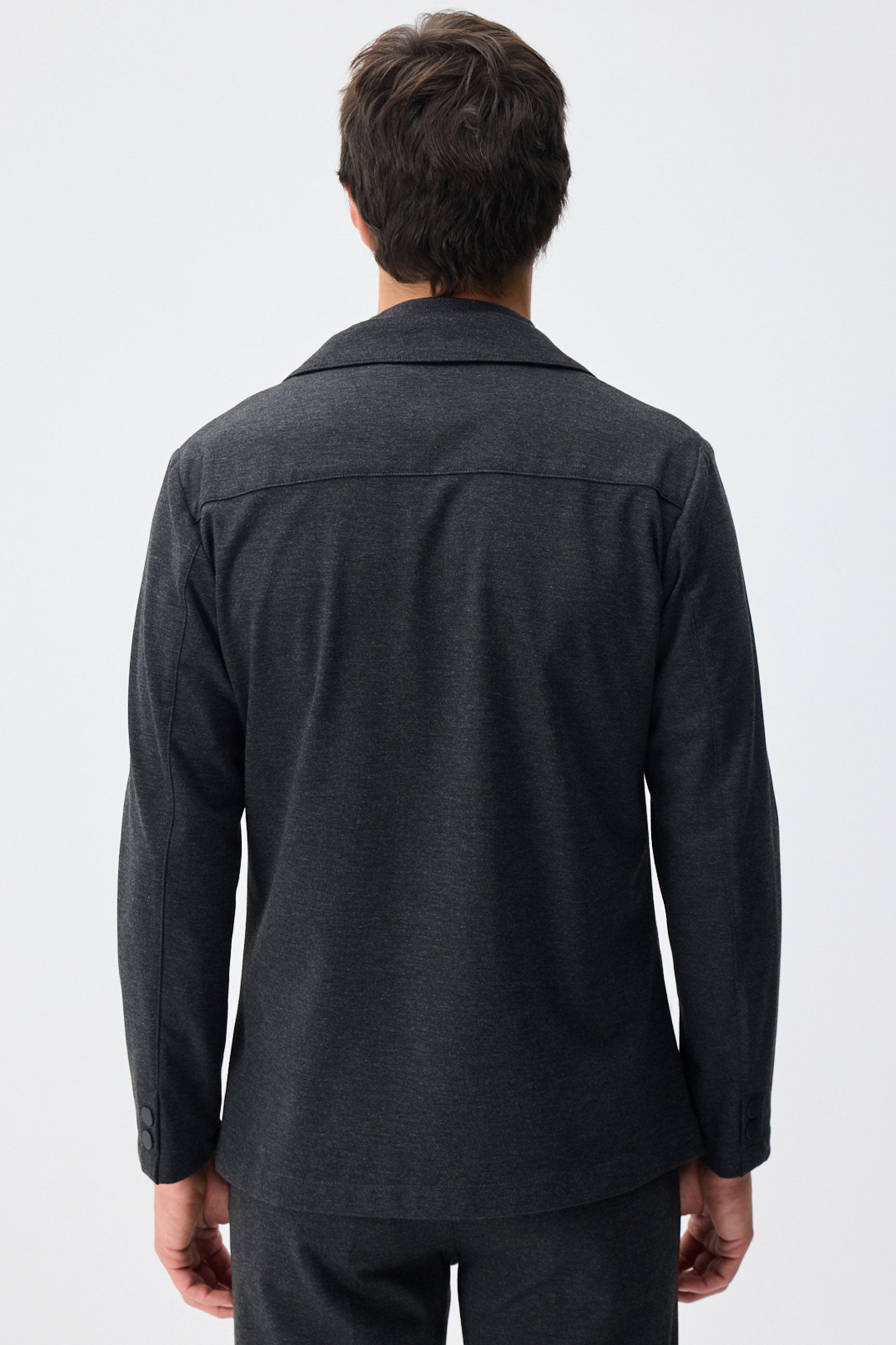 Blazer masculino cinza-escuro em malha macia, estilo casual elegante.