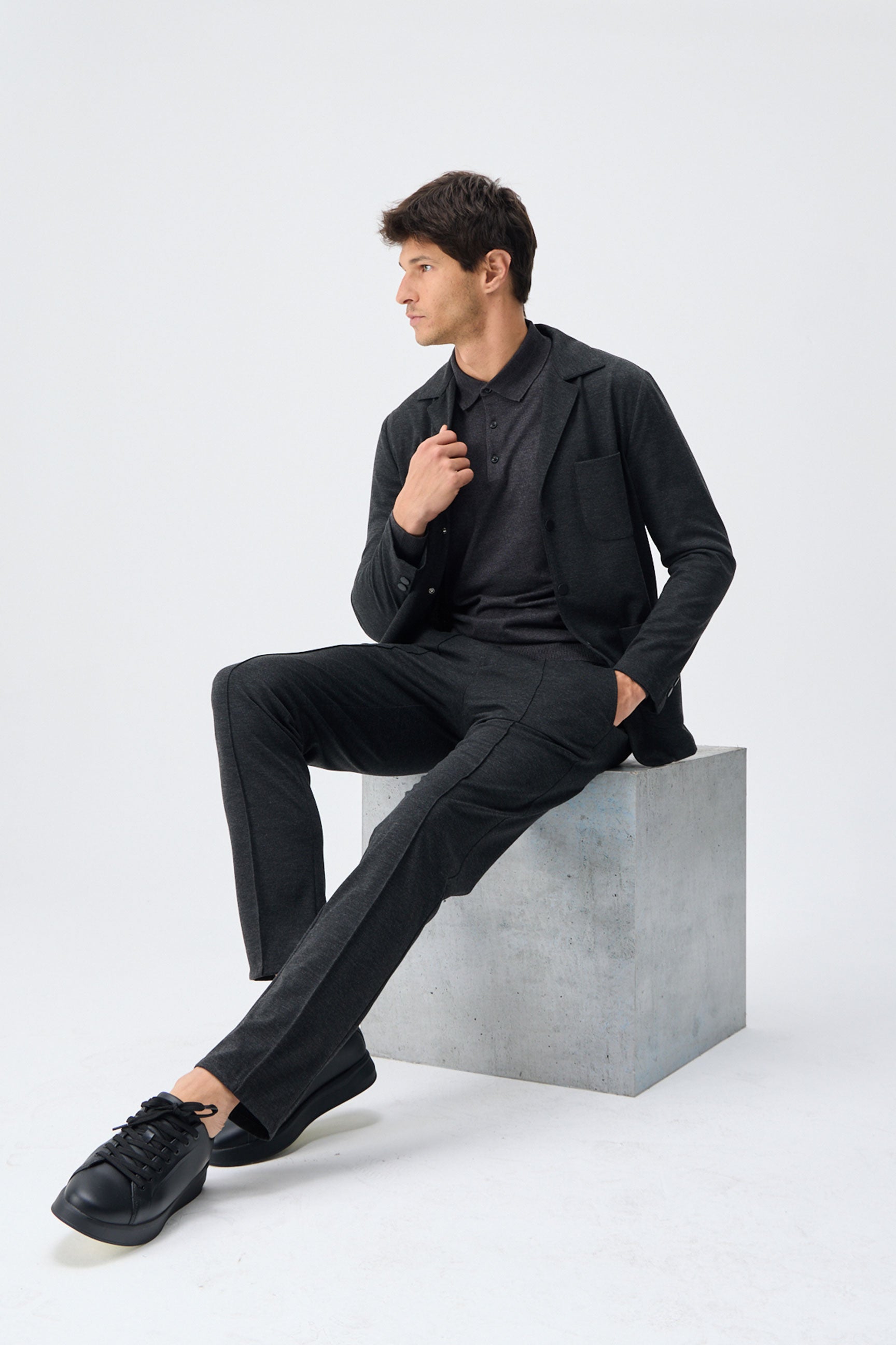 Blazer masculino cinza-escuro em malha macia, estilo casual elegante.