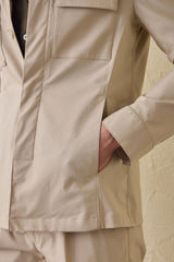 Terno masculino bege casual elegante de duas peças estilo safari com gola alta e tecido elástico.