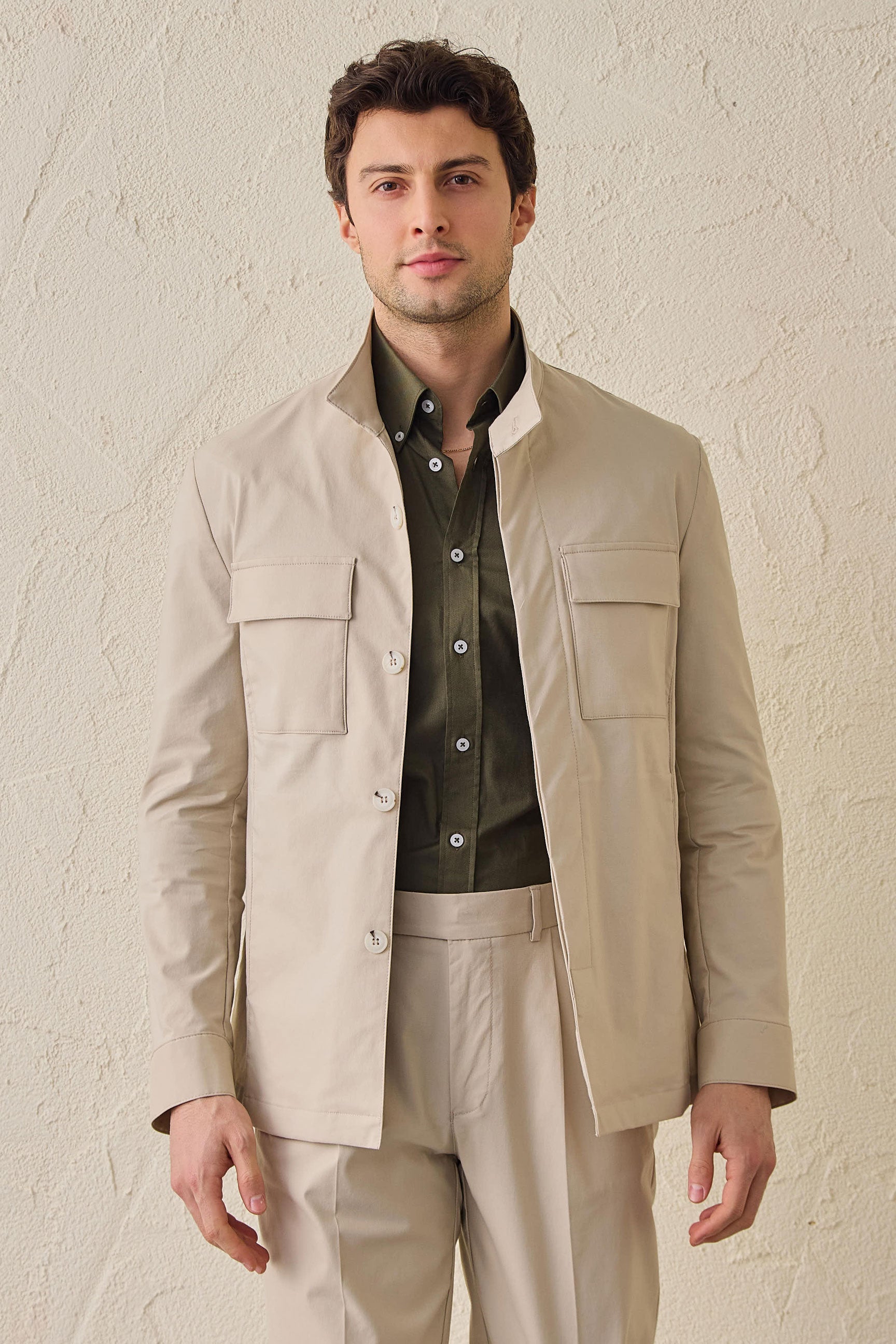 Terno masculino bege casual elegante de duas peças estilo safari com gola alta e tecido elástico.