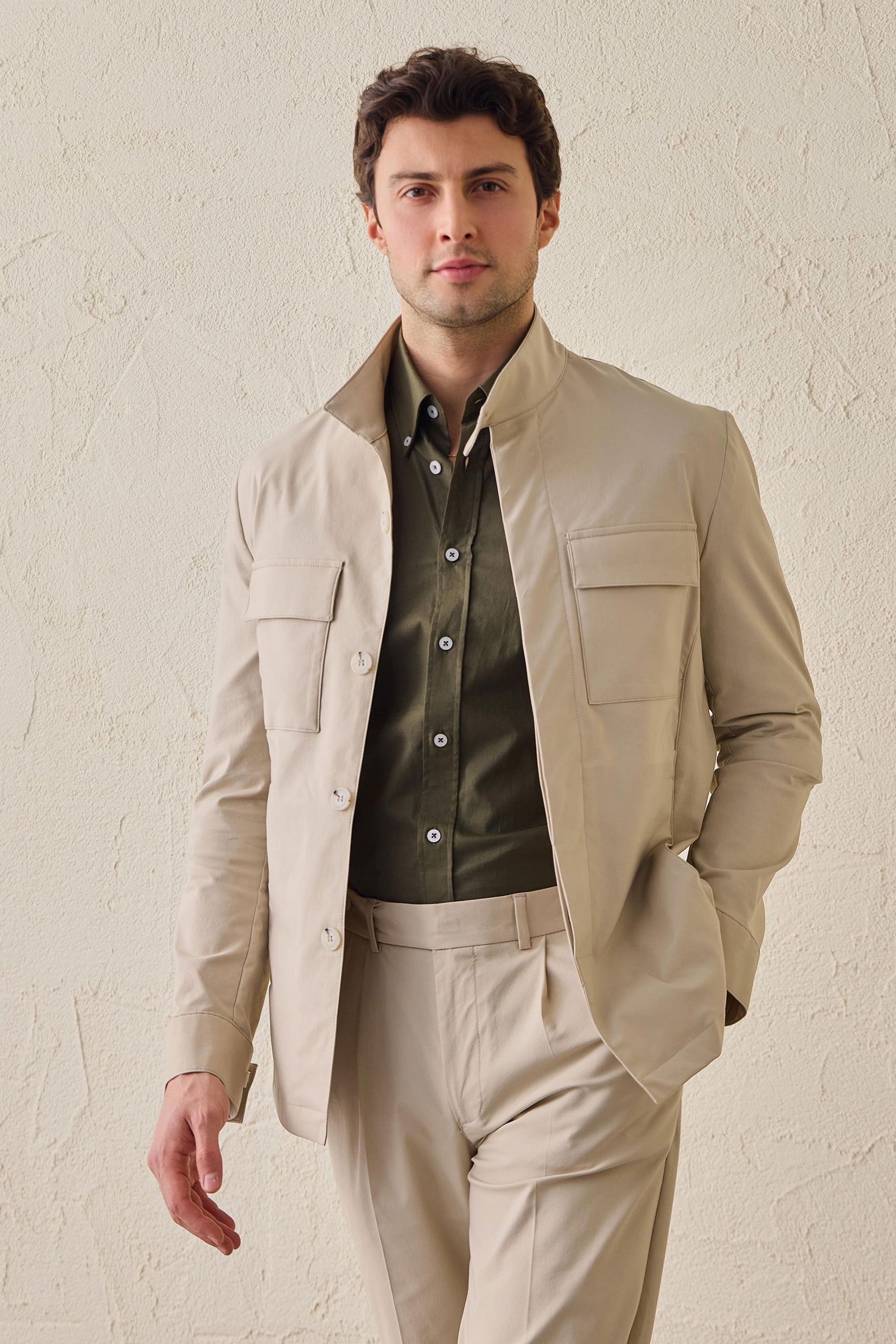 Terno masculino bege casual elegante de duas peças estilo safari com gola alta e tecido elástico.