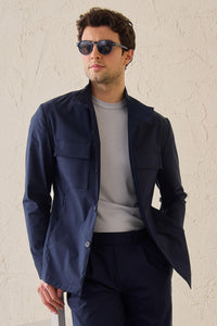 Terno masculino azul-marinho estilo safari, duas peças, elegante e casual, com gola alta e tecido elástico.