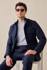 Terno masculino azul-marinho estilo safari, duas peças, elegante e casual, com gola alta e tecido elástico.