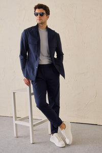 Terno masculino azul-marinho estilo safari, duas peças, elegante e casual, com gola alta e tecido elástico.