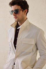 Terno masculino branco de duas peças, estilo safari, com gola alta e tecido elástico.