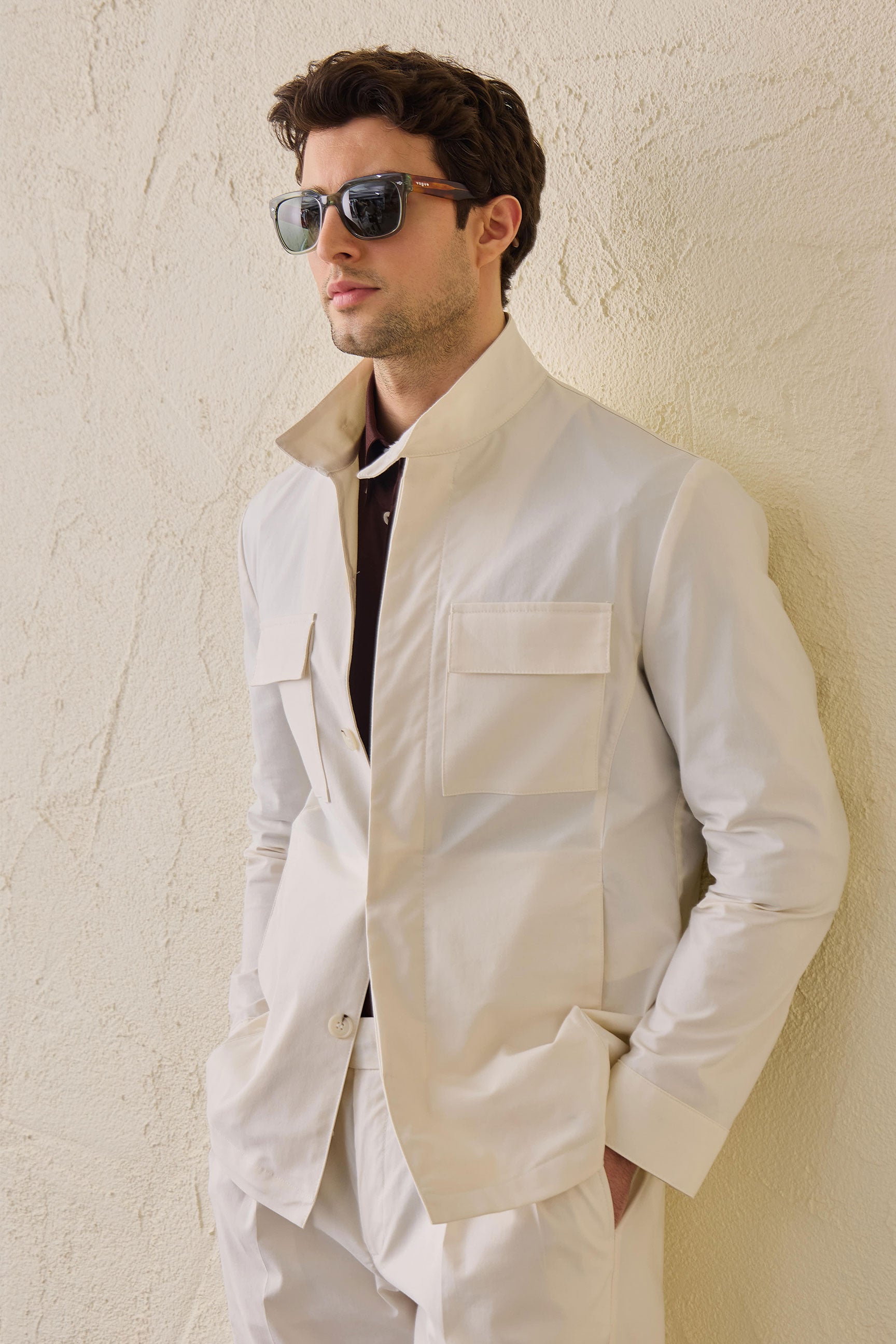 Terno masculino branco de duas peças, estilo safari, com gola alta e tecido elástico.