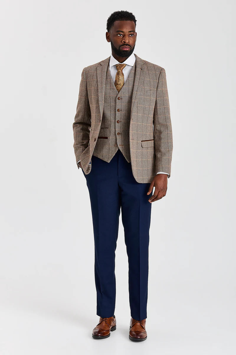Terno Harris em tweed marrom com calças Mayfair azul-marinho contrastantes.