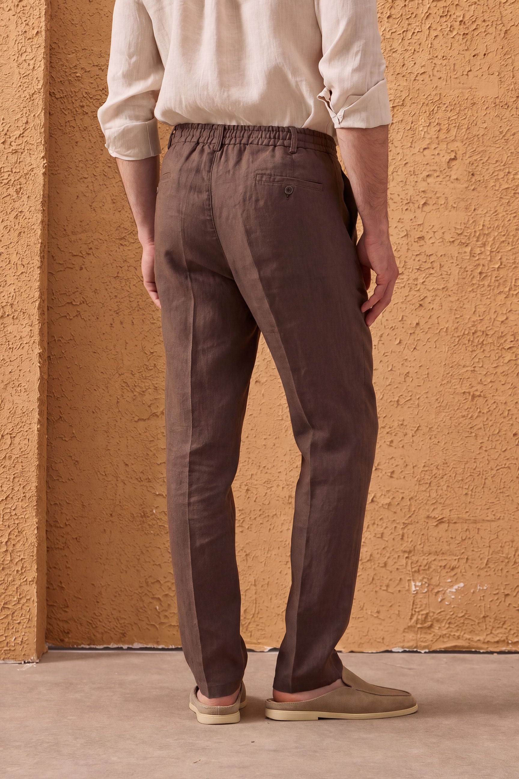 Conjunto masculino de jaqueta de linho verde-sálvia com zíper e calça marrom, look casual elegante para o verão.