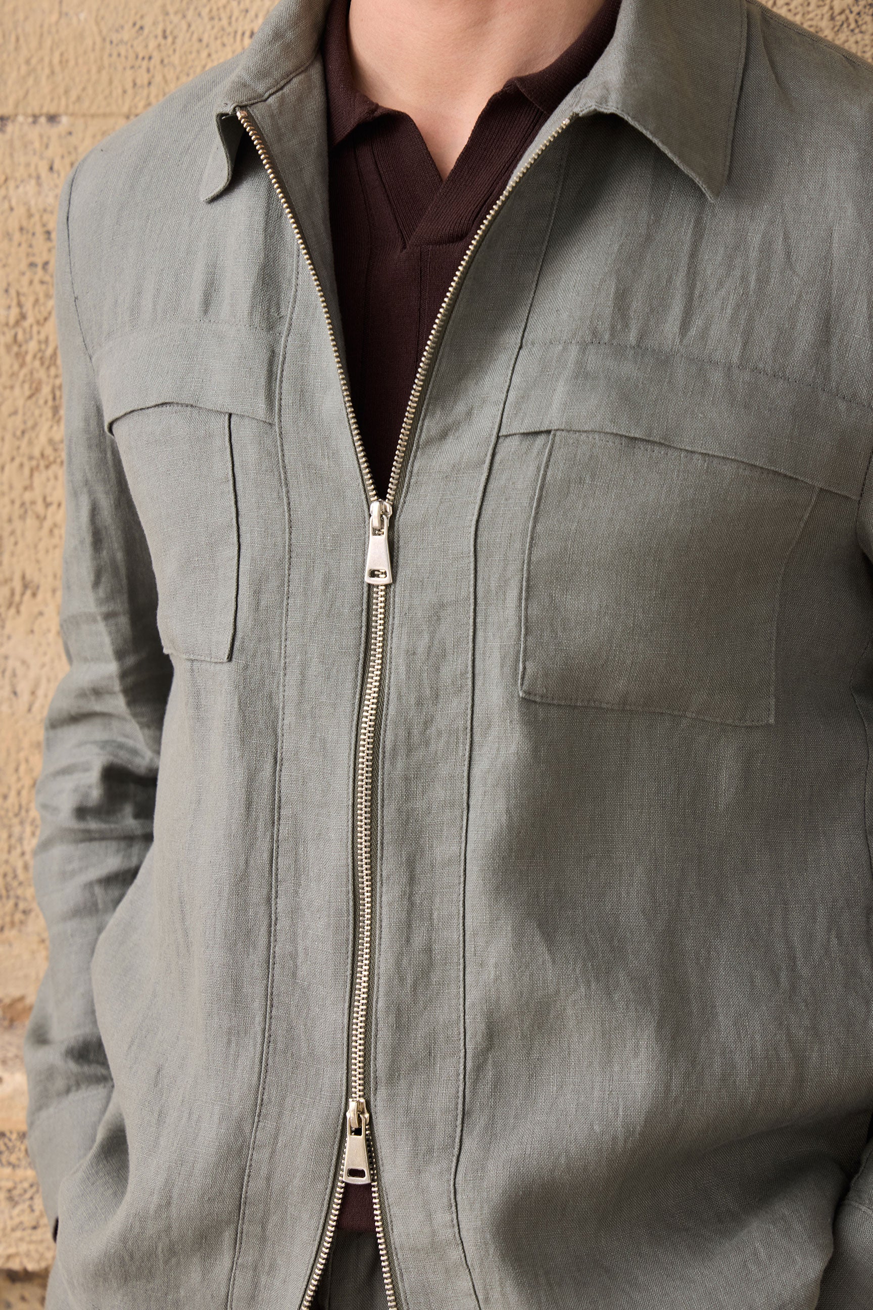Conjunto masculino de jaqueta de linho verde-sálvia com zíper e calça marrom, look casual elegante para o verão.