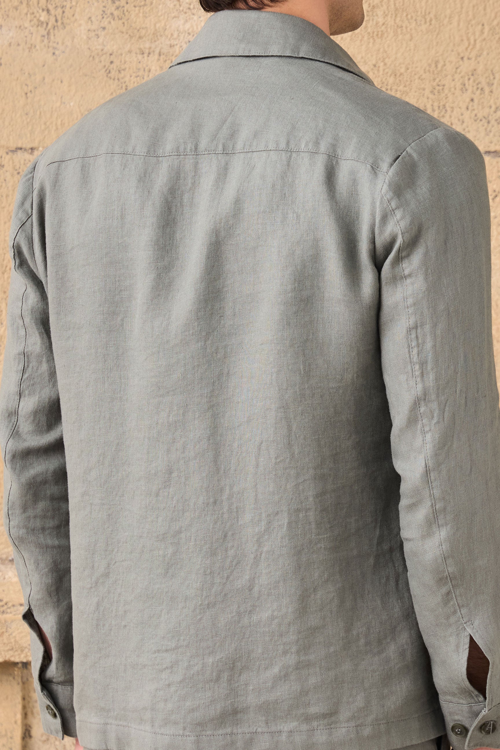 Conjunto masculino de jaqueta de linho verde-sálvia com zíper e calça marrom, look casual elegante para o verão.