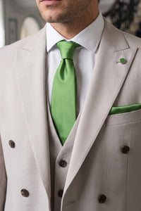 Conjunto masculino de gravata verde com lenço de bolso e abotoaduras combinando.