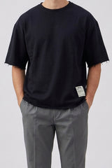 Camiseta masculina azul-marinho escura, modelagem relaxada, barra desfiada, gola redonda, em mistura de algodão.